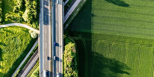aerial view of a road crossing green fields - Photo by Bernd Dittrich on Unsplash