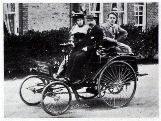 A man and woman in an old fashioned car