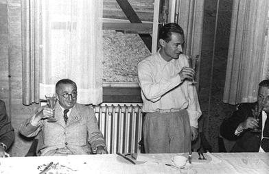 Men raising their glasses in a toast, at a party